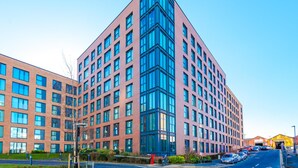 Un edificio moderno de varios pisos con una sección angular destacada y grandes ventanales.