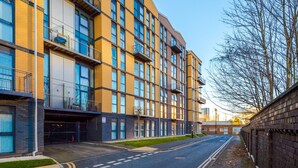 A multi-story building with a modern architectural design, featuring balconies and large windows. - Skeek Groundfloor Apartment with Wine Fridge (Birmingham)