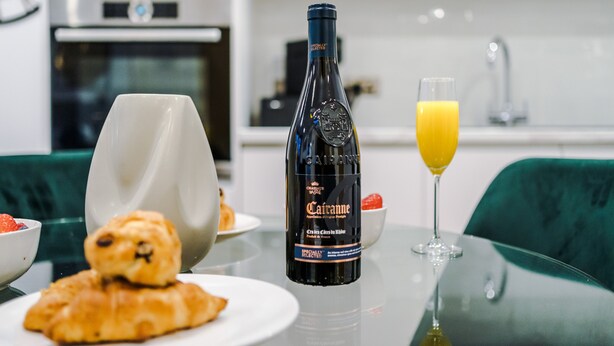 A breakfast setting with a bottle of Cava, a glass of orange juice, croissants, and a bowl of strawberries. - Skeek Groundfloor Apartment with Wine Fridge (Birmingham)