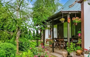 A house with a porch, potted plants, and a garden. - Cozy apartment in Chwarzenko with WiFi (Chwarzenko)