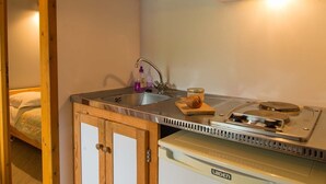 Una cocina compacta con un lavamanos, estufa y armarios de madera.