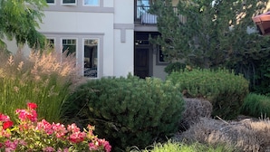 A two-story house with a balcony, surrounded by various shrubs and trees. - Modern, king beds, pools, parks, pet OK, 5 mins toYMCA ,Store and top golf (Meridian)