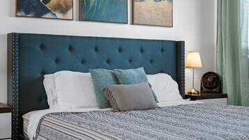 A neatly made bed with a tufted headboard, a patterned bedspread, and decorative pillows.