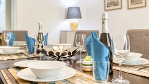 Une table à manger dressée avec des assiettes, des verres et une bouteille de champagne.