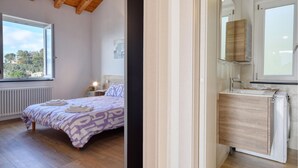 A bedroom with a bed, a bedside table, a window, and a view of trees and buildings outside. - 1 bedroom lovely apartment in Recco (Recco)