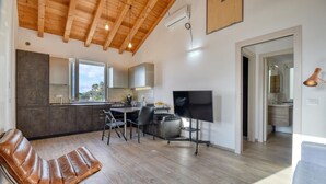 A modern kitchen with a dining area, a TV, and a leather chair. - 1 bedroom lovely apartment in Recco (Recco)