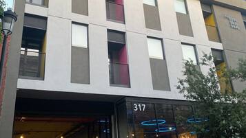 Contemporary building with a flat facade and rectangular windows, featuring a glass entrance and clean lines.
