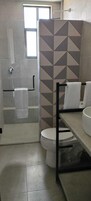 Een badkamer met een douche, toilet en wastafel.