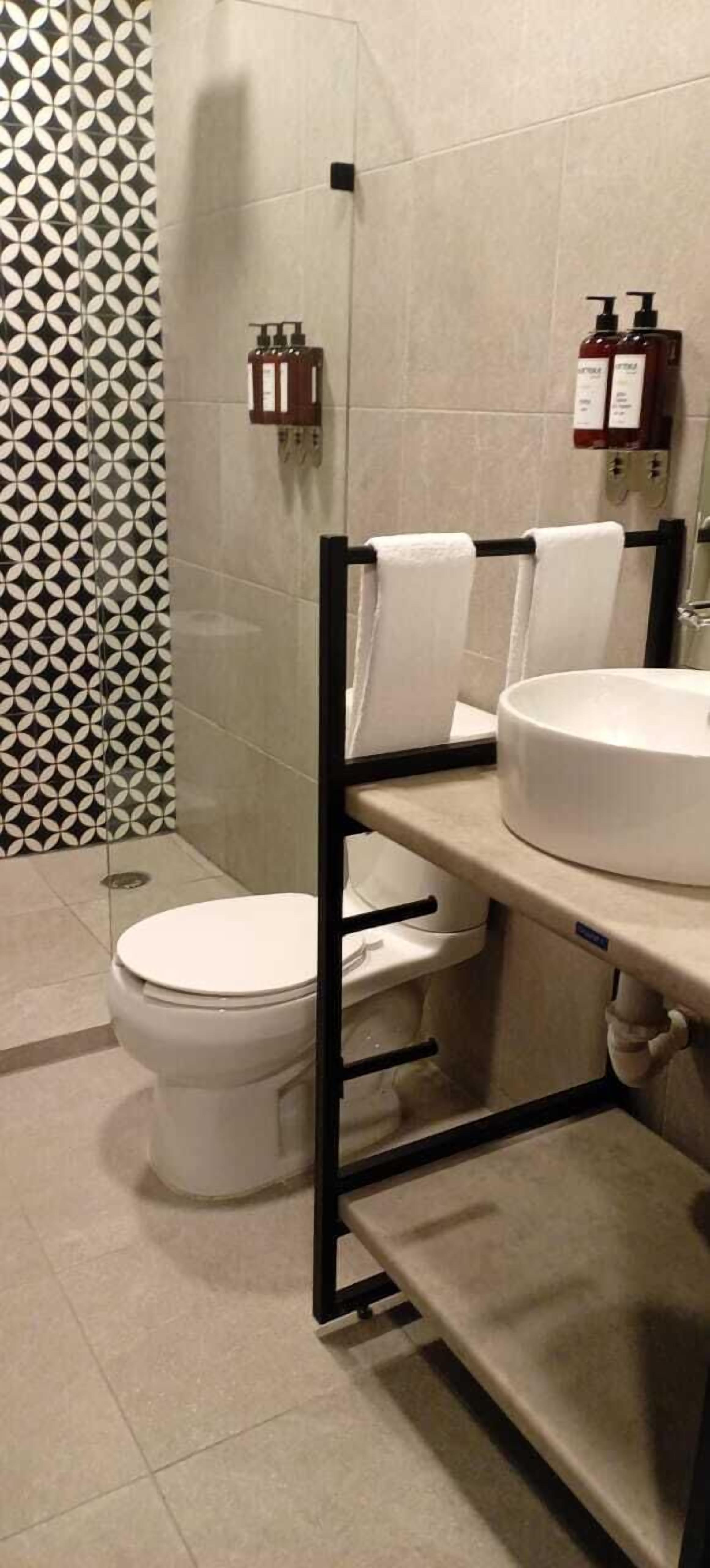 Un bagno moderno con un water, un lavandino e un portasciugamani.