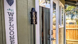 A wooden exterior with a 'WELCOME' sign, a glass door, and a lantern.