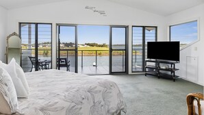Una camera da letto con un letto, una TV e vista su un lago.