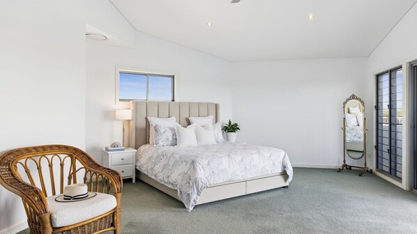 A bedroom with a bed, nightstand, chair, and a mirror. - Jeffery River Retreat - Pet Friendly With Private Pontoon - Holiday Yamba (Yamba)