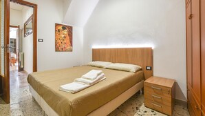 A bedroom with a bed, a nightstand, a wooden wardrobe, and a painting on the wall. - 1 bedroom cozy apartment in Chiaramonte Gulfi (Chiaramonte Gulfi)