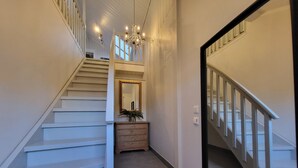 A staircase with white railings, a wooden dresser, a mirror, and a chandelier. - Mercury House, Cathedral View! Free parking! (Trøndelag)