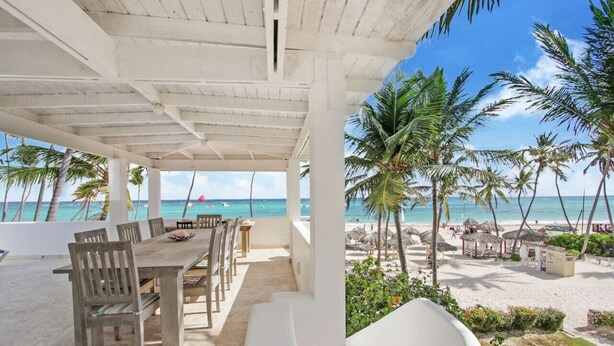 A covered outdoor dining area with a view of the beach and ocean. - Casa Caribe: NEW beachfront, oceanview condo w/ housekeeper & rooftop terrace (Punta Cana)
