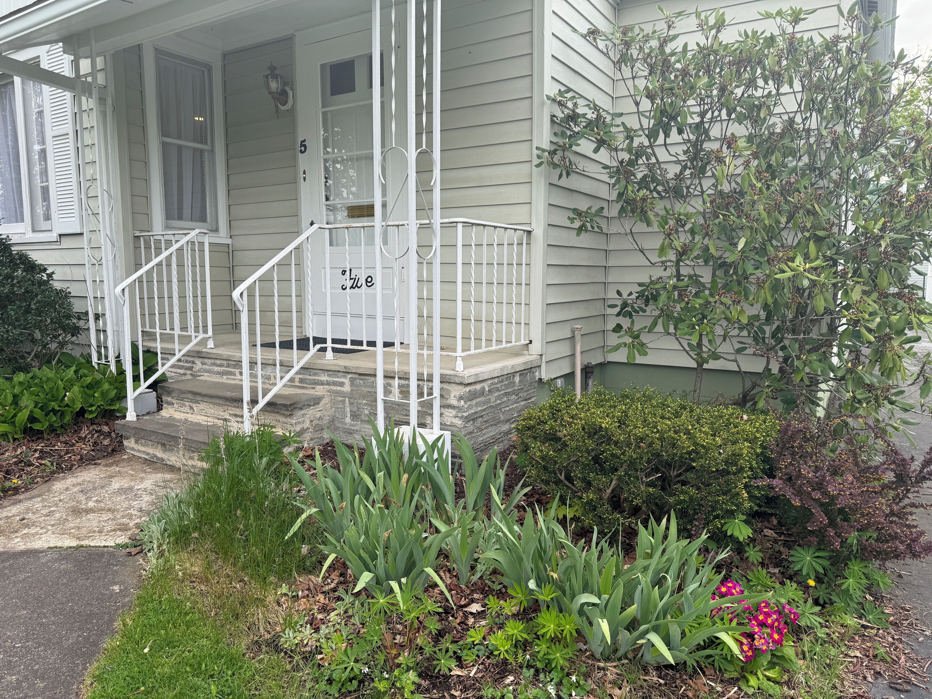 A house with a porch, steps, and a mailbox.