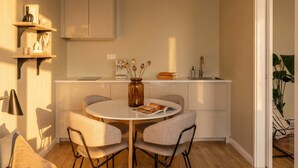 A compact kitchen with a round dining table, chairs, and a built-in oven.
