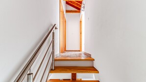 Una escalera de madera con barandillas de metal que conduce a un piso superior.