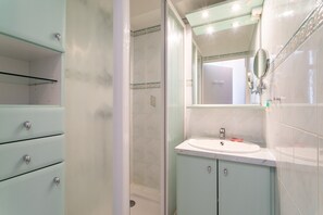 A bathroom with a shower, a sink, and a mirror. - Apartment 'Appartement Canet Plage Front Mer' with Sea View, Private Terrace and Air Conditioning (Canet Plage)