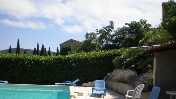 A swimming pool with lounge chairs and a hedge. - Les Sources Gite Cabernet House with Shared Pool, Private Terrace, and Air Conditioning (Chambonas)
