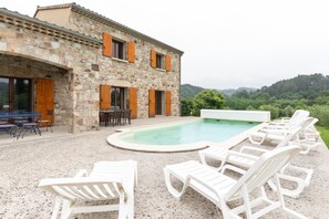 A stone building with a swimming pool and outdoor seating. - Small House 'Les Sources Gîte La Grange' with Shared Pool, Private Terrace (Chambonas)