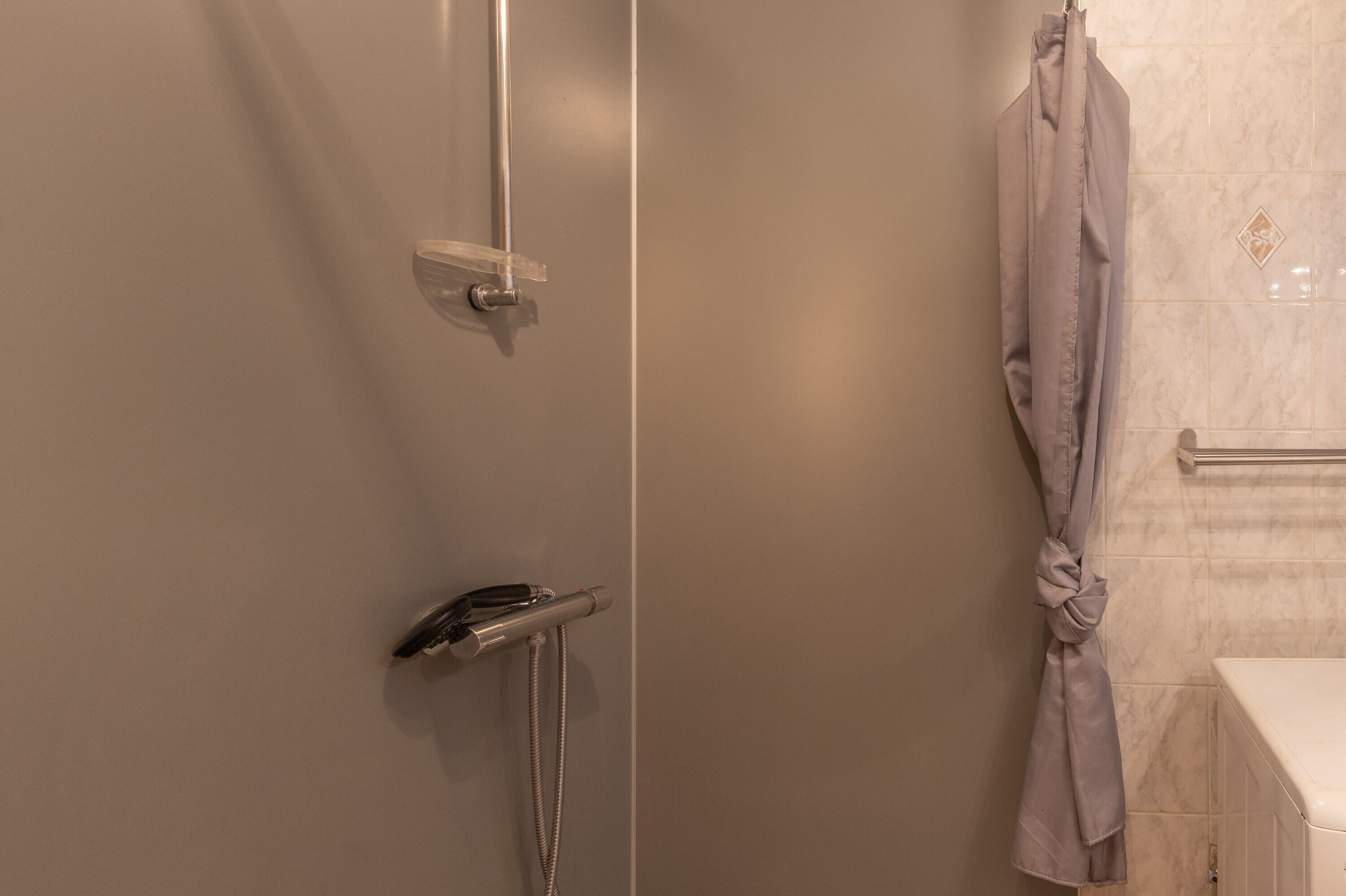 Une salle de bain avec une douche, un porte-serviettes et une baignoire.