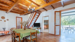 A dining area with a table set for four, a television, and a staircase leading to an upper level. - Holiday Home 'Ciumara East' with Private Terrace, Wi-Fi and Air Conditioning (Avola)