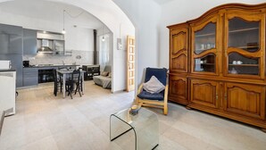 Una cocina moderna con comedor, un armario de madera y una mesa de vidrio.