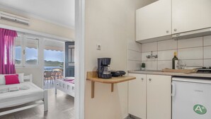A modern kitchen with a coffee machine, a wine bottle, and a refrigerator. - Apartment 'Standard  with Sea View 2' with Sea View, Wi-Fi and Air Conditioning (Nikiana)
