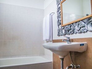 Deep-soaking bathtub, rainfall showerhead, designer toiletries