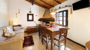 Un salon chaleureux avec une table à manger en bois, des chaises, un canapé et une cheminée.