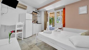 Ein Schlafzimmer mit einem Bett, einem Schreibtisch, einem Stuhl, einem Fernseher und einem Fenster.