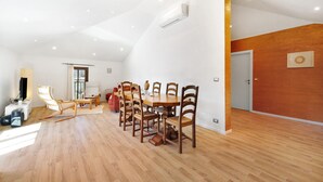 A spacious dining area with wooden flooring, a large table, and several chairs. - Apartment 'La Terrazza Del Tempo' with Mountain View, Wi-Fi and Air Conditioning (Castelvecchio di Rocca Barbena)