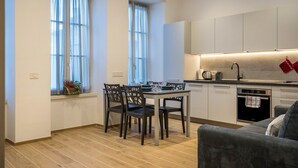 Una cocina moderna con una mesa de comedor, sillas y un horno empotrado.