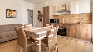 Una cocina moderna con comedor, armarios de madera, microondas y horno empotrado.