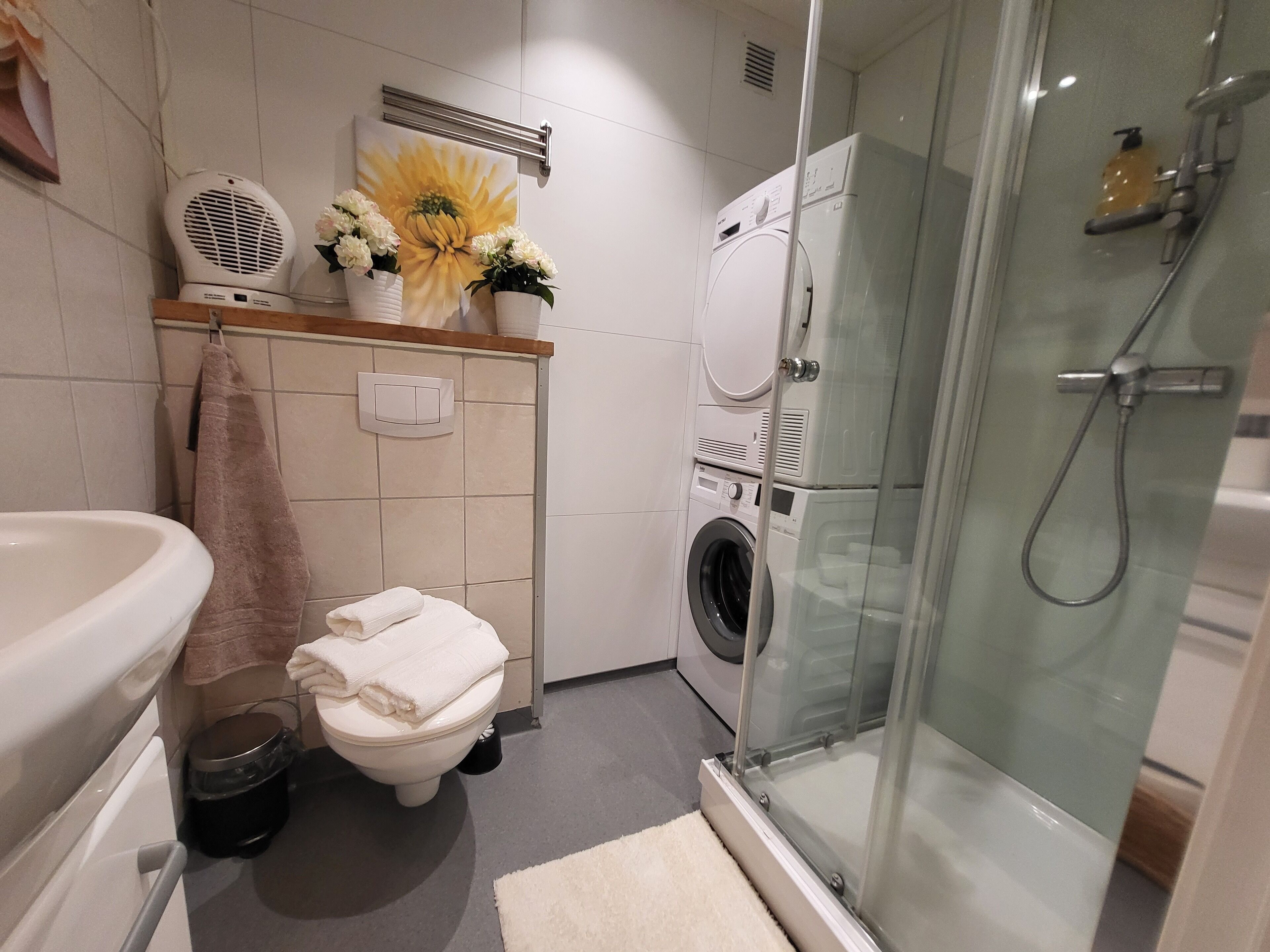 Een haardroger, handdoeken, zeep, toiletpapier