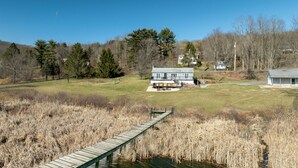 A house with a deck and a pond in the foreground. - Dock is waiting!  Fishing, paddleboards, kayaking!!
Come relax by the Lake! (Copake)