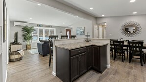 A modern kitchen with dark cabinetry, a granite countertop, and a dining area with wooden chairs. - Dock is waiting!  Fishing, paddleboards, kayaking!!
Come relax by the Lake! (Copake)