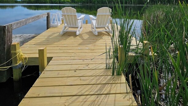 A wooden dock with two white chairs facing a calm lake, surrounded by greenery and a cloudy sky. - Dock is waiting!  Fishing, paddleboards, kayaking!!
Come relax by the Lake! (Copake)