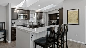A modern kitchen with a central island, dark cabinetry, stainless steel appliances, and a skylight. - Dock is waiting!  Fishing, paddleboards, kayaking!!
Come relax by the Lake! (Copake)