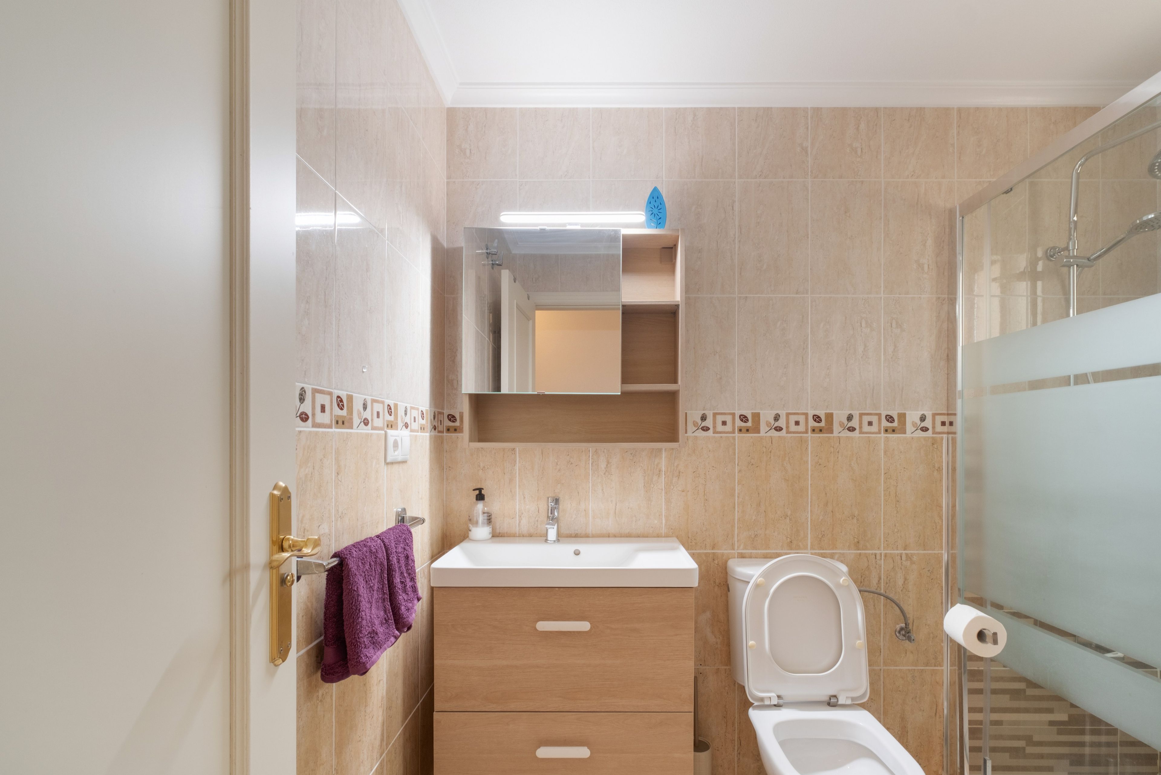 Un baño con inodoro, lavabo y espejo.