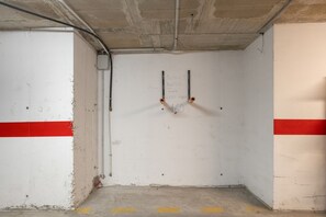 A parking garage with concrete walls, a red stripe, and a yellow line on the floor. - Apartment 'Carpediem in Spanje' with Lake View, Shared Pool and Wi-Fi (San Miguel de Salinas)