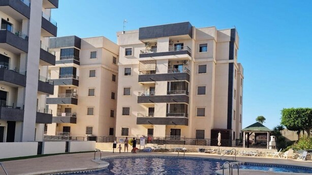 A multi-story hotel with balconies, a swimming pool, and outdoor seating. - Apartment 'Carpediem in Spanje' with Lake View, Shared Pool and Wi-Fi (San Miguel de Salinas)