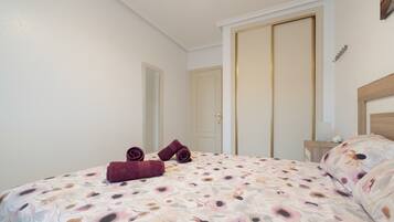 Una camera da letto con un letto, un comodino, uno specchio e una porta.
