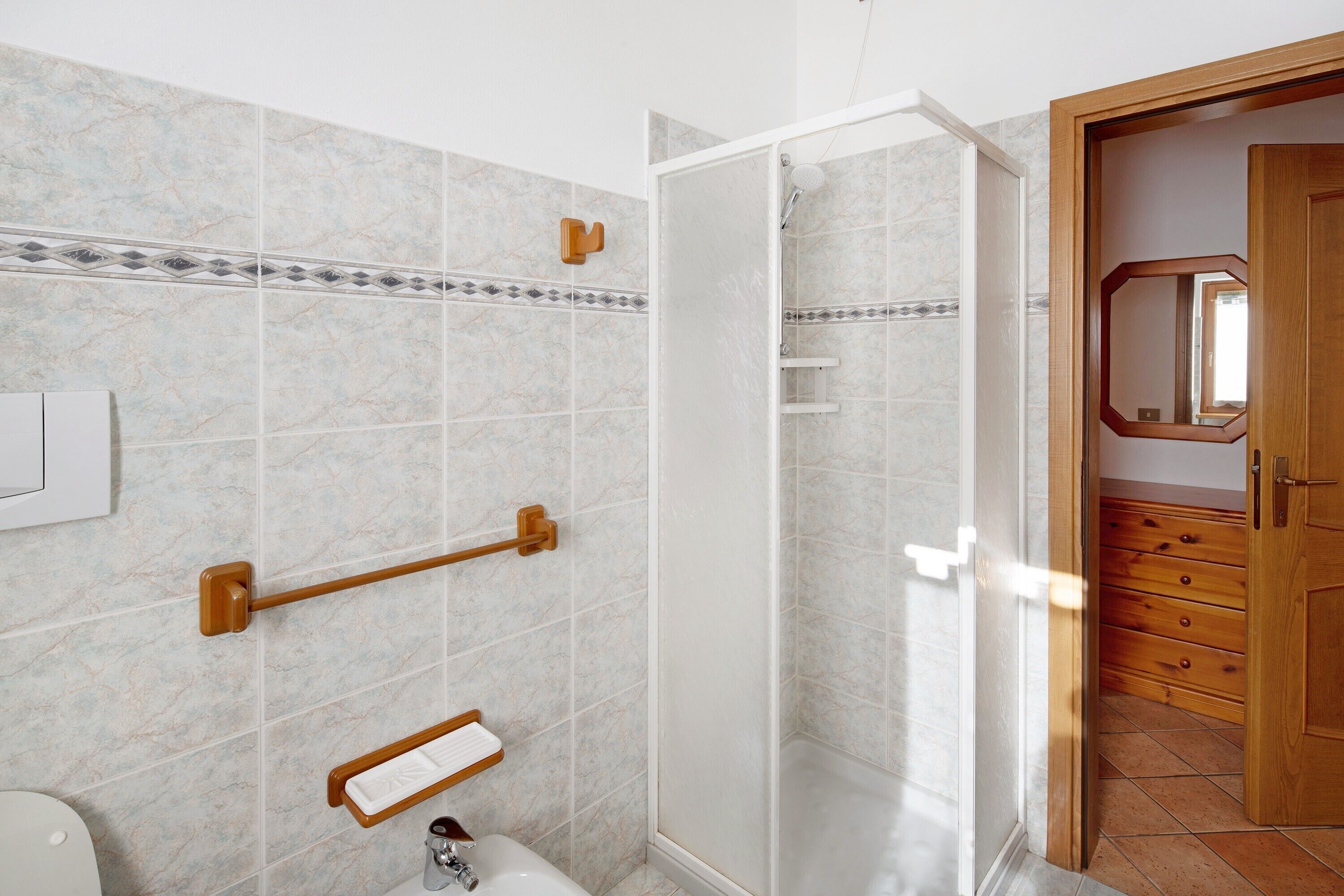A bathroom with a shower, a toilet, and a sink.