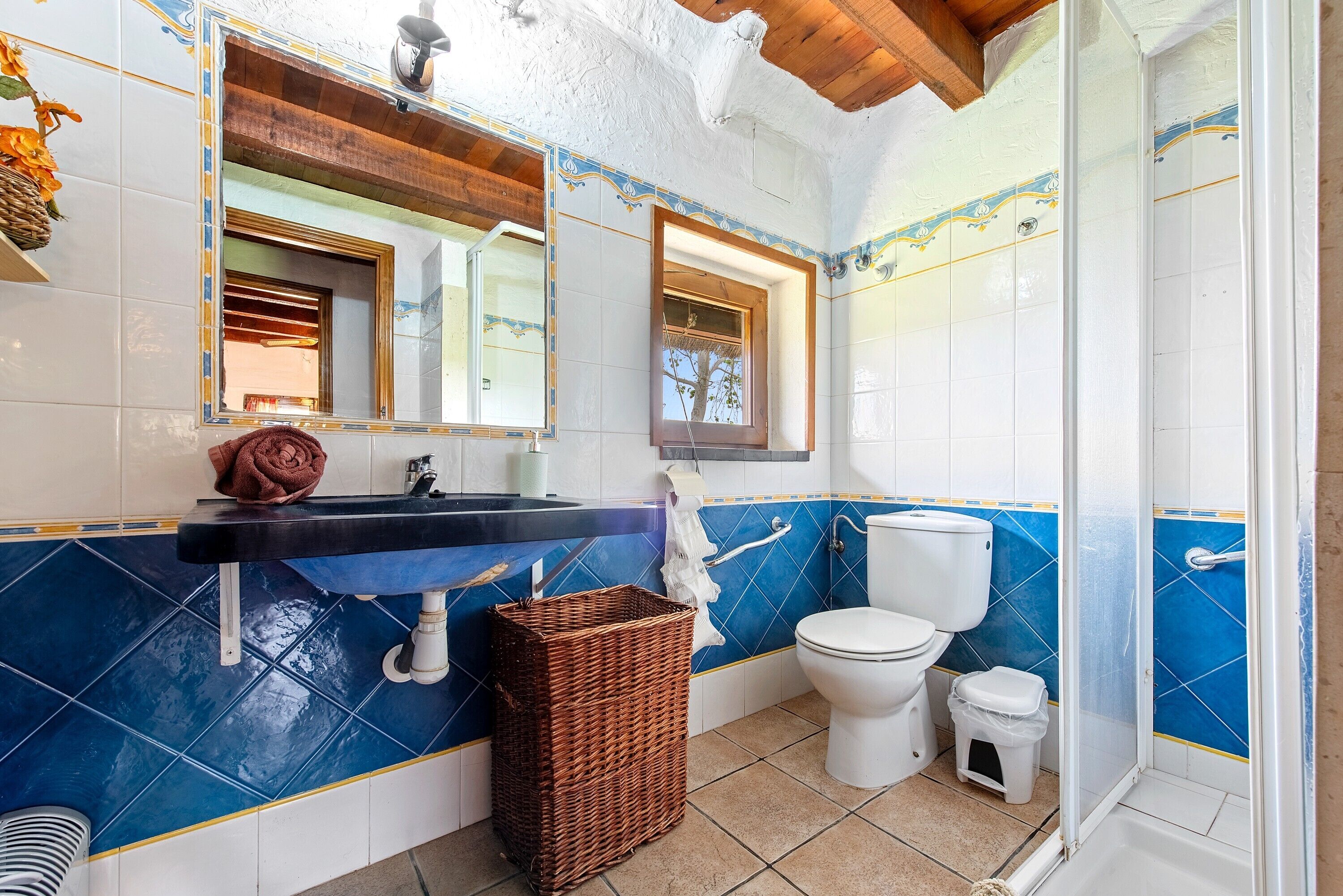 Ein Badezimmer mit Waschbecken, Spiegel, Toilette und Dusche.