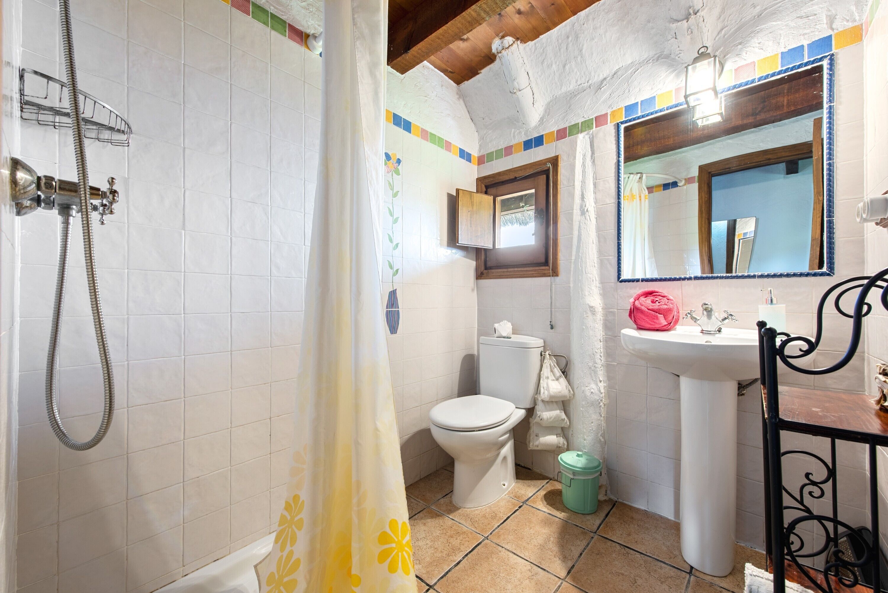 Un baño con ducha, inodoro, lavabo y espejo.