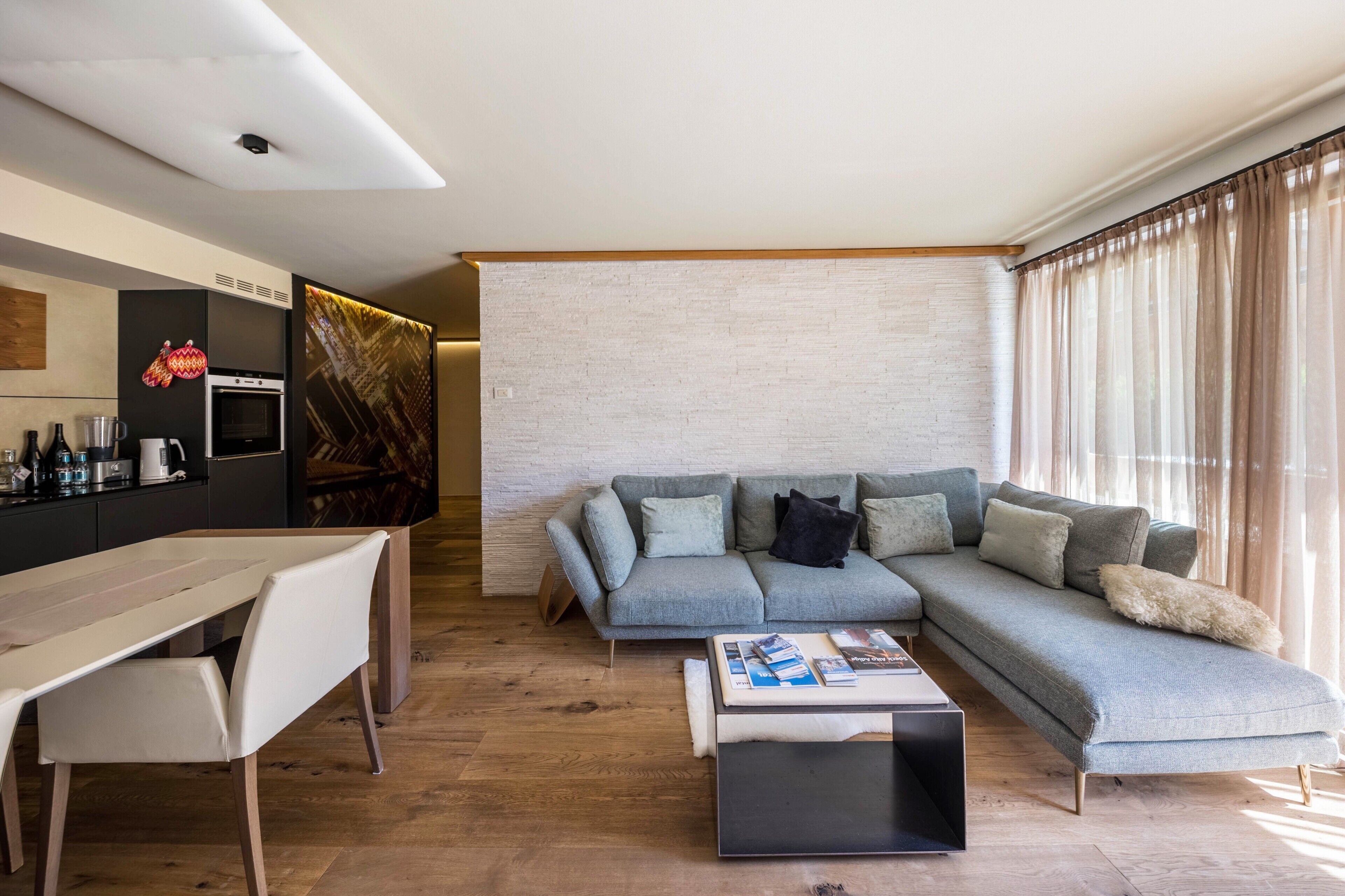 Una sala de estar moderna con un sofá, una mesa de centro y un comedor con una mesa y sillas.