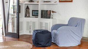 A room with a seating area, a bookshelf, and a door with a glass panel. - Charming Holiday Home with Sea Views, Private Pool and Wi-Fi (Binibèquer)