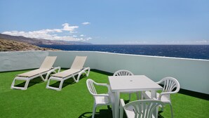 A terrace with white lounge chairs and a table, overlooking the sea. - Vacation Home 'Casa  Fefa' with Sea View and Private Terrace (Candelaria)